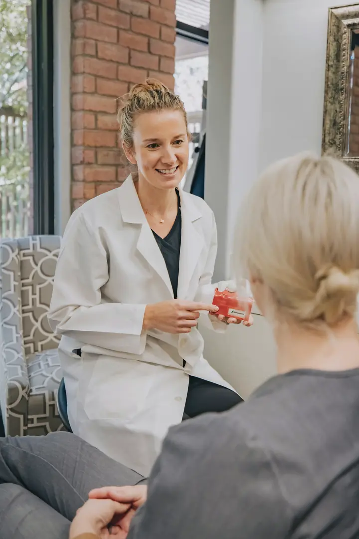 A physician in a white coat talking with a patient in a calm consultation lounge