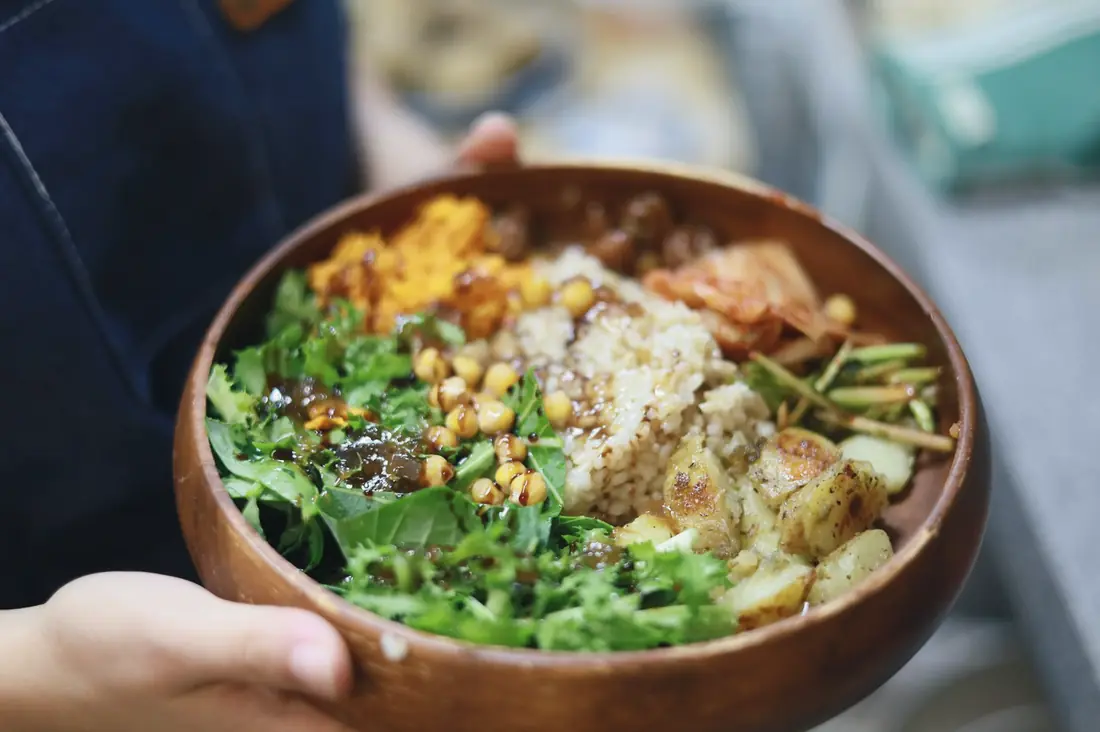 A bowl of rice, chickpeas, greens and vegetables